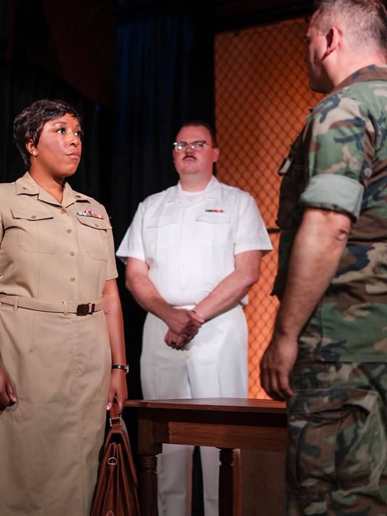 Joanne Galloway faces a performer in camouflage uniform.