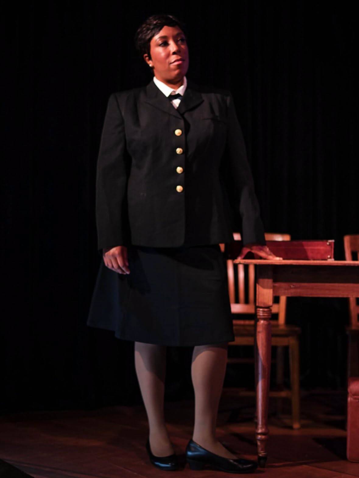Joanne Galloway stands in dress uniform beside courtroom furniture.